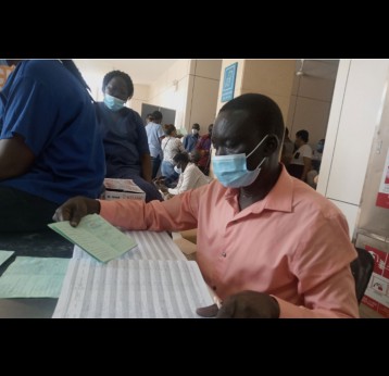 A healthcare worker at Juba Teaching Hospital crosschecks vaccination details in a card