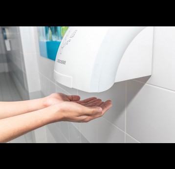 Automatic hand dryer in public toilet or restroom