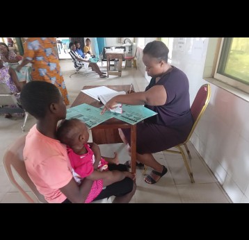 Adetunji Bimpe and her daughter being attended to by immunisation staff. Credit: Ijeoma Ukazu