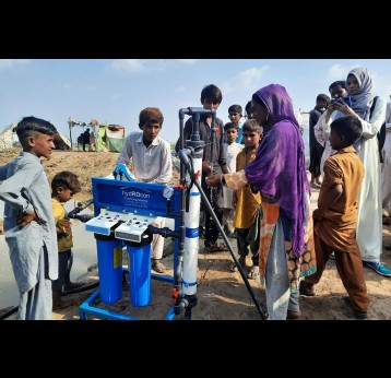 People get clean drinking water from a portable water filter pump manufactured by Faisal Mubarak.