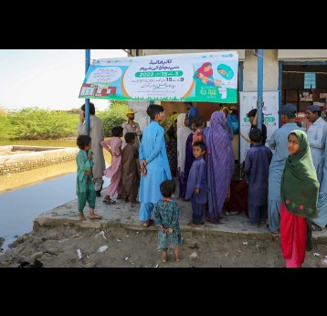 Families outside a vaccination center in flooded Pakistan. Credit: Gavi/2022/Asad Zaidi
