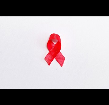 The red ribbon, the universal symbol of awareness and support for people living with HIV. Photo by Anna Shvets from Pexels