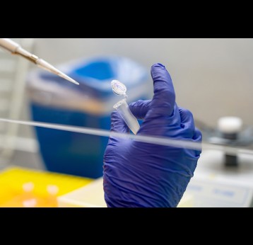 Scientifique mettant un échantillon dans un flacon pour une analyse ADN.
