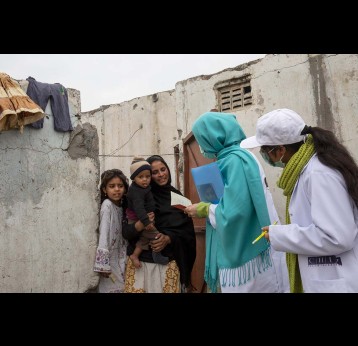 Health workers talking to a mother with unvaccinated children in Islamabad. Credit: Gavi/2020/Asad Zaidi