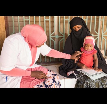 A baby plays with their mother and a health worker at CSI Nouveau Marché, a health centre in Niamey, Niger. Credit: Isaac Griberg/Gavi/2022