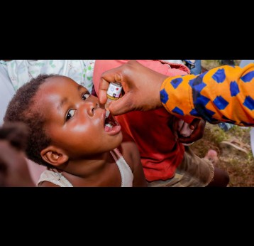 Un enfant recevant un vaccin oral contre la polio, administré par un agent de santé communautaire. Crédit : Diane Ndonse