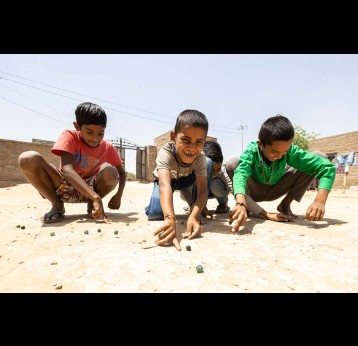A group of young boys play with marbles in Deshnoke, Rajasthan, India. Credit: Gavi/2021/Benedikt v.Loebell