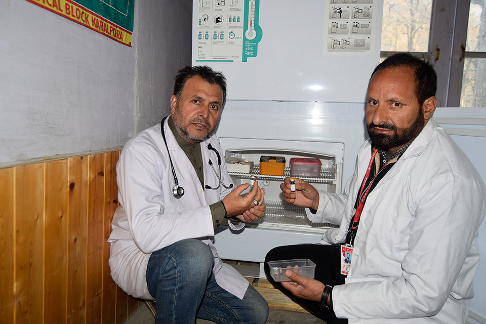 Health officials check the vaccine vials in one of India’s vaccine cold storage terminals in Keran in northern Kashmir.