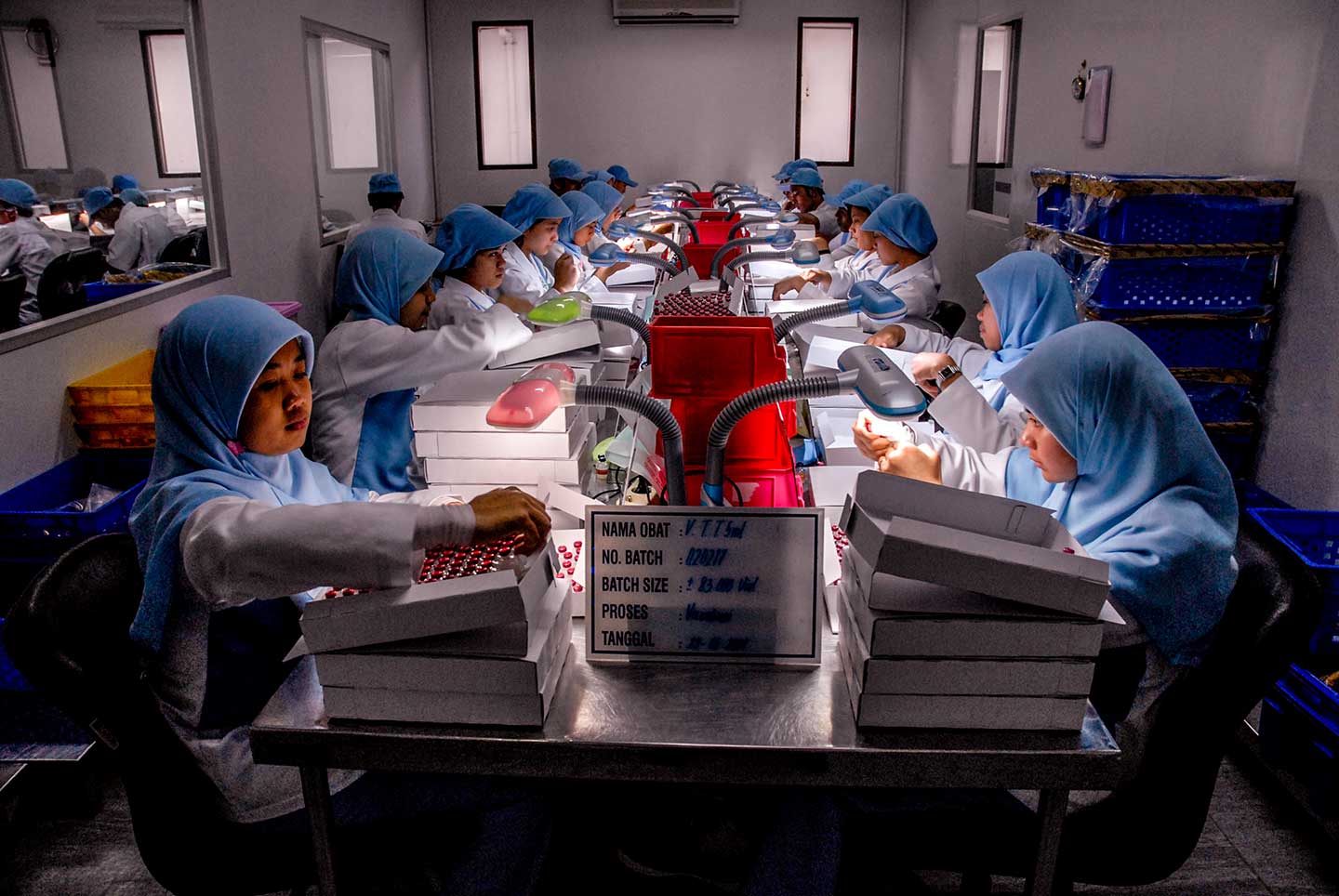 Workers look at the filling process of HepB vaccine filled in Uniject syringes at the Bio Farma serum factory. Credit: Edy Purnomo