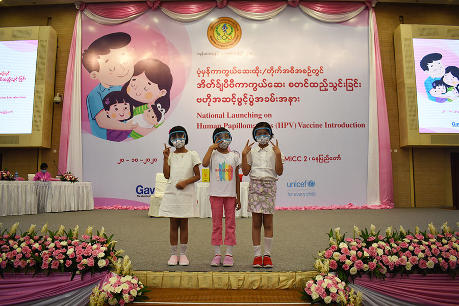 The first three girls to receive the HPV vaccine in Myanmar stand on stage together. Gavi/2020