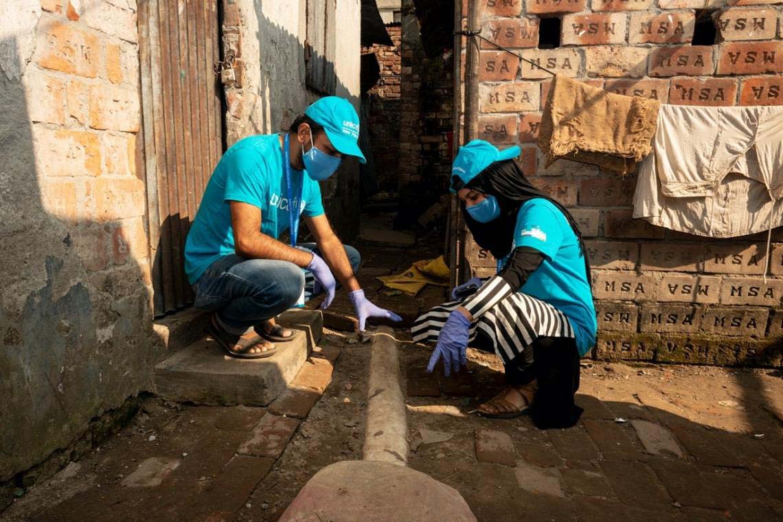@ UNICEF Bangladesh/2020/Satu UNICEF volunteers Mohammed Nazmul Huda Nasim, 25 and Humayra Rezyona, 23, inspect a sewage line. The line was broken and posed dangers to the local community.