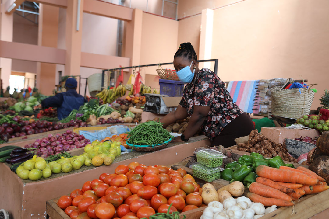 Vaccinated and masked businesswoman selling vegetables at Oloitiptip Market in Kilifi County