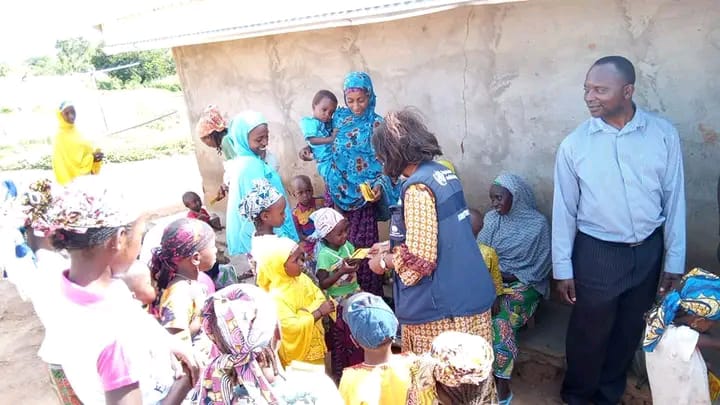 Un agent de santé de l'OMS distribue des cartes de vaccination contre la fièvre jaune aux enfants d'un campement de Bororo dans la localité de Makak, à l'ouest Cameroun le 2 juin 2022(Ishiak Grand Royal)