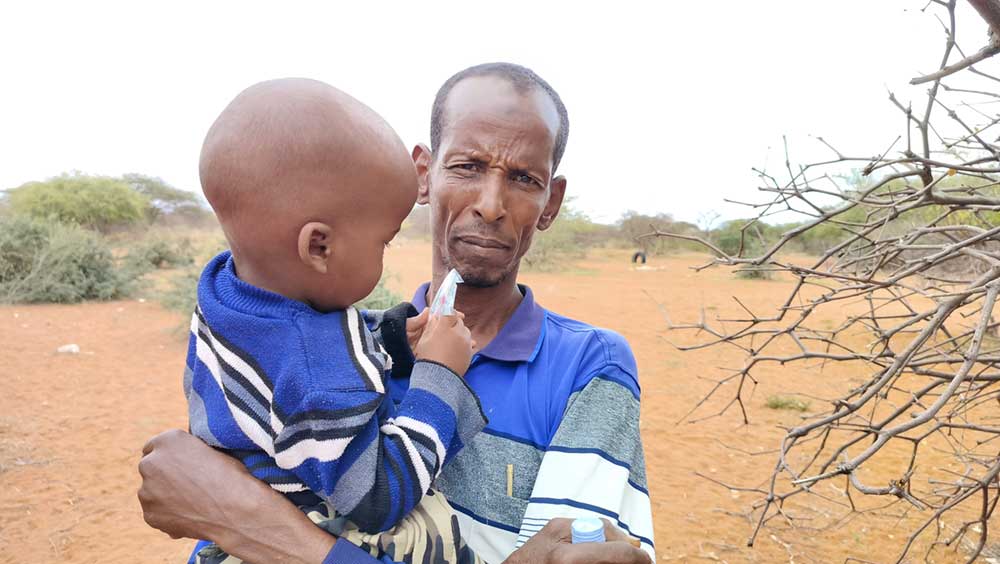 Farah Kalmoy holds his son while awaiting to be attended to at the at a mobile clinic in Abdiaziz, Wajir County , Kenya. Credit:,Angeline Anyango