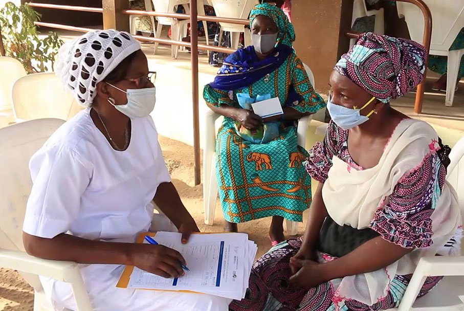 The midwife fills in the questionnaire before carrying out a cervical smear. Credit: Edna Fleure