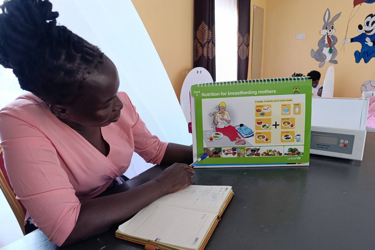 Evaline Awino, a community health worker takes Sheila Awuor, a new mother, through a breastfeeding training session on 24 June 2024. Credit: Angeline Anyango