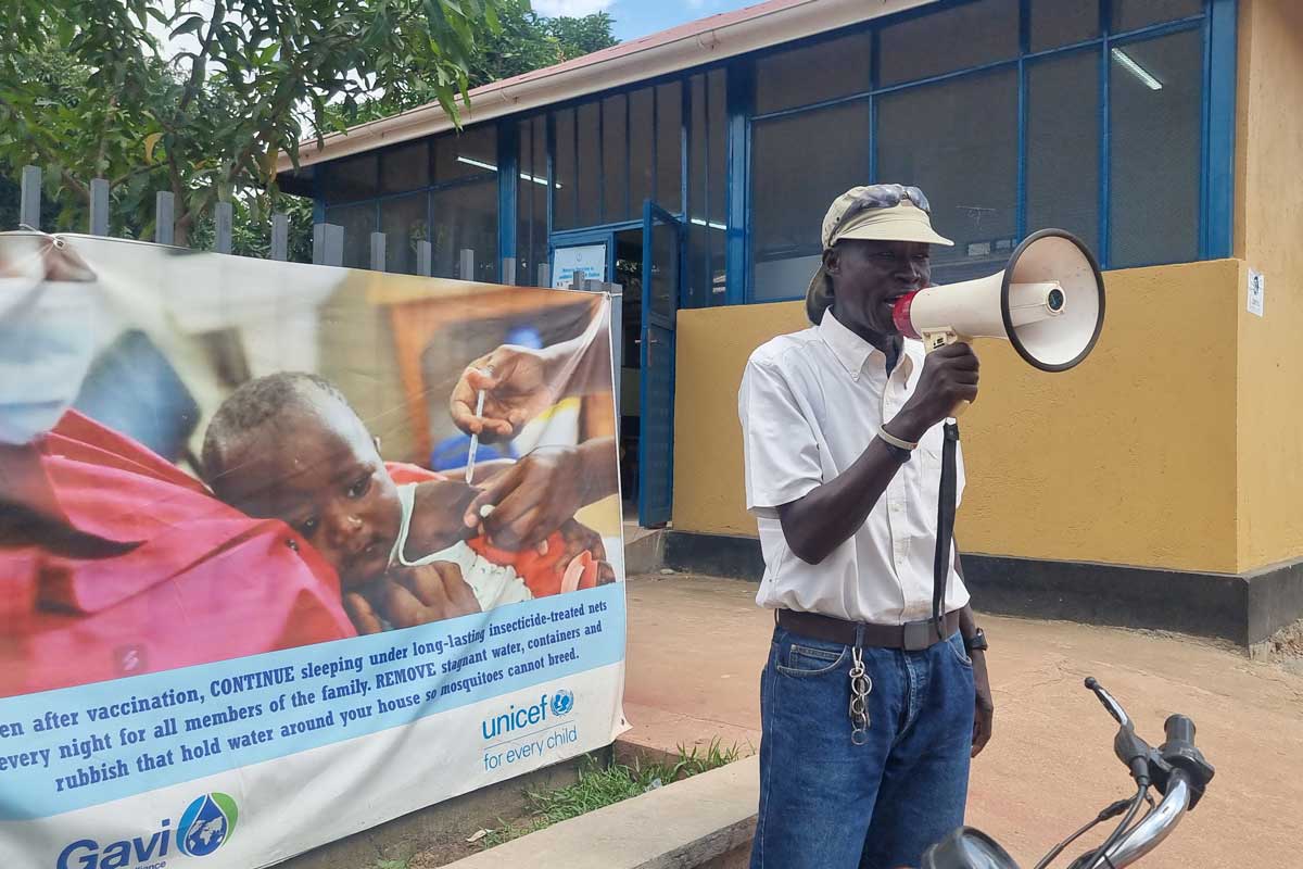 Community Mobiliser Abiah James Karaba  and his megaphone tout the newly introduced malaria vaccine at Al Sabbah Hospital. Credit: Winnie Cirino.