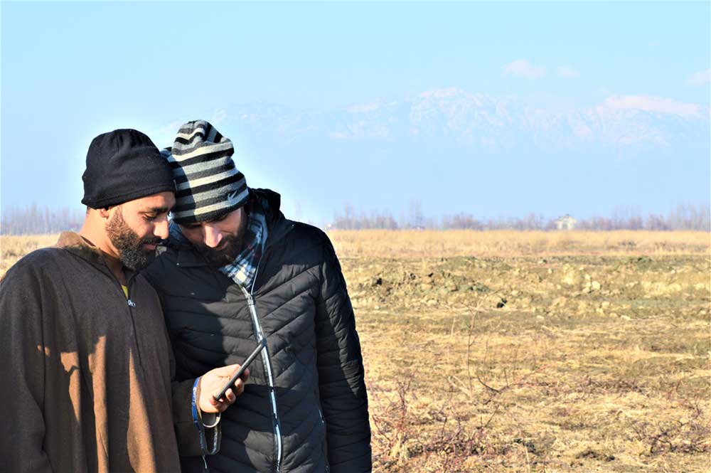 Two youth beside a dried up wetland during a long winter drought in Kashmir Himalayas. Photo by Parvaiz Bhat