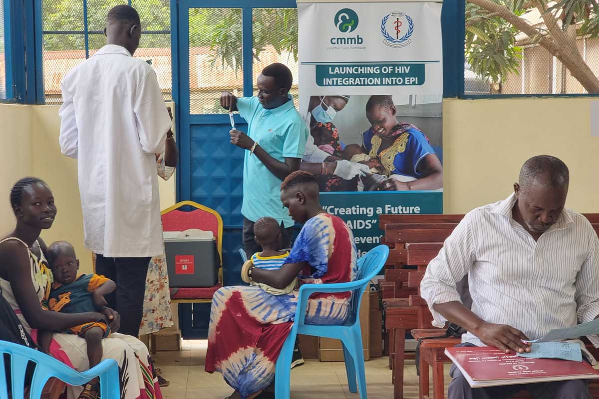 Lillian Gune waits in the queue for her child to be vaccinated. Credit: Winnie Cirino.