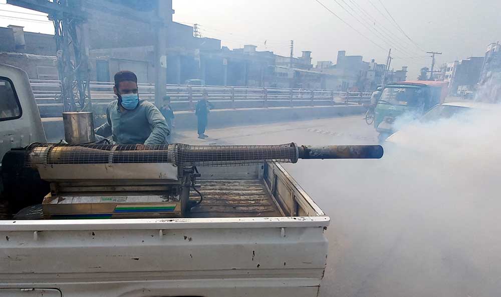 3. 当地政府部门的一名雇员正在巴基斯坦白沙瓦市进行雾化行动，作为遏制疟疾和登革热传播的预防措施的一部分。
