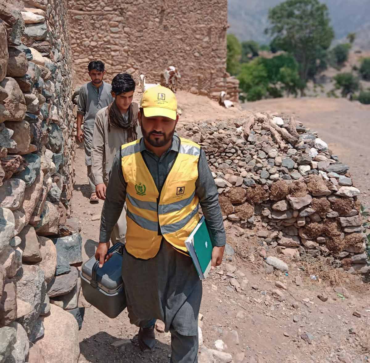 Abdul Rahim Safi, a vaccinator with EPI Khyber Pakhtunkhwa, during his immunisation duties in Mohmand District of Khyber Pakhtunkhwa in the sizzling heat of June. The vaccines carried in the special ice box as part of the cold chain are fully protected from the hot weather. Credit: Adeel Saeed.