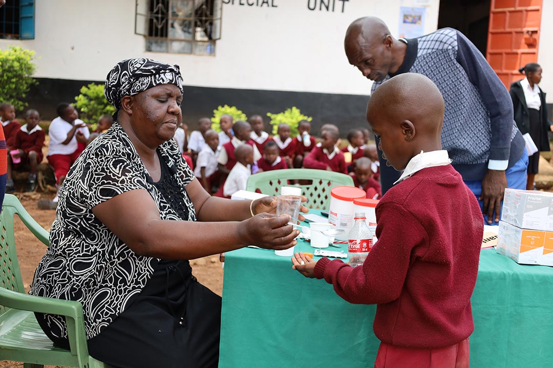 A teacher at Kadika Primary School in Migori County, Kenya, administers deworming treatments to pupils, as part of the National School-Based Deworming Programme 2023 deworming drive. Credit: Evidence Action