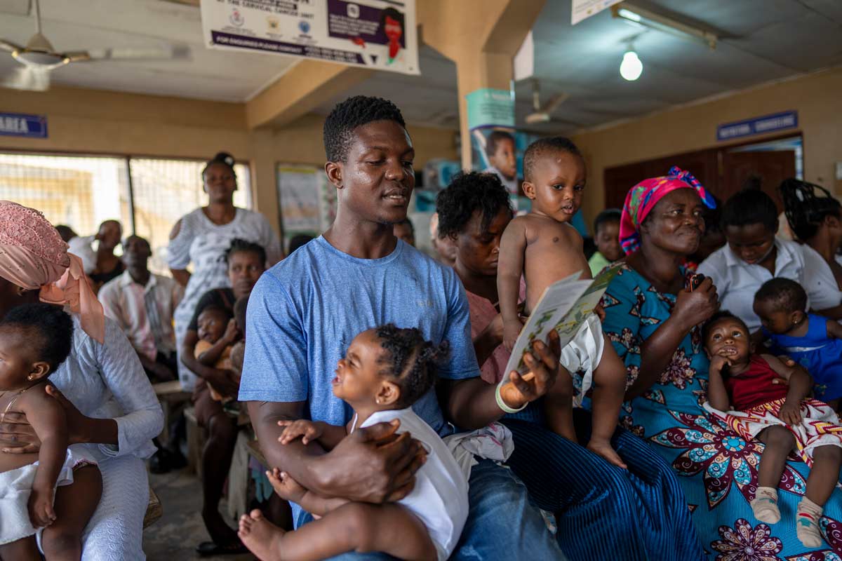 A father brings his daughter for weighing and malaria vaccination in Ghana. Credit: The Global Fund/Nana Kofi Acquah