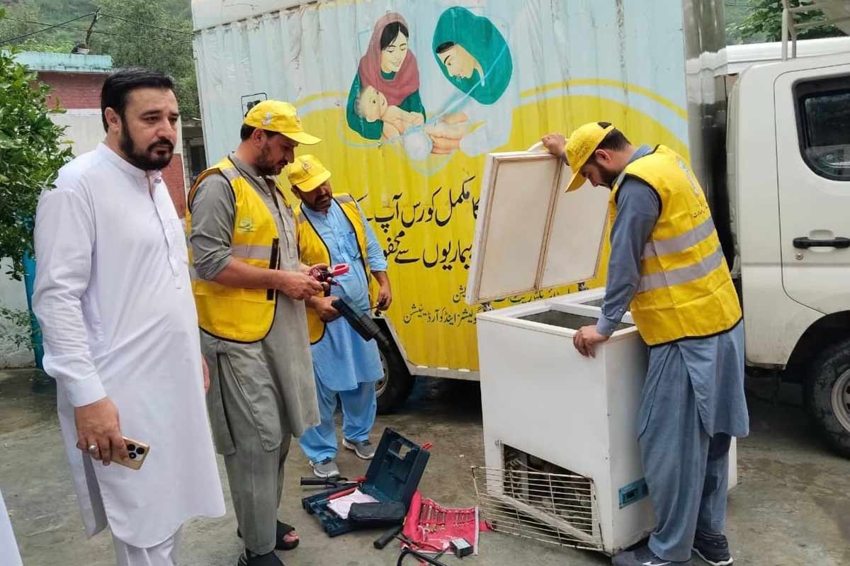 A mobile workshop team repairs a fridge used to store vaccines. Credit: KP/EPI