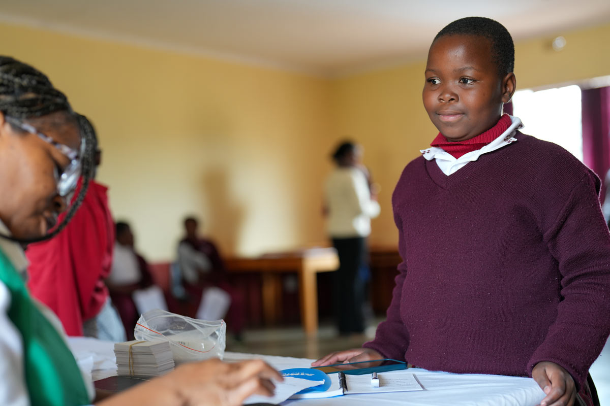 A girl with a health worker during a HPV vaccination session in Eswatini. Credit: Gavi/2025/Svetlomir Slavchev