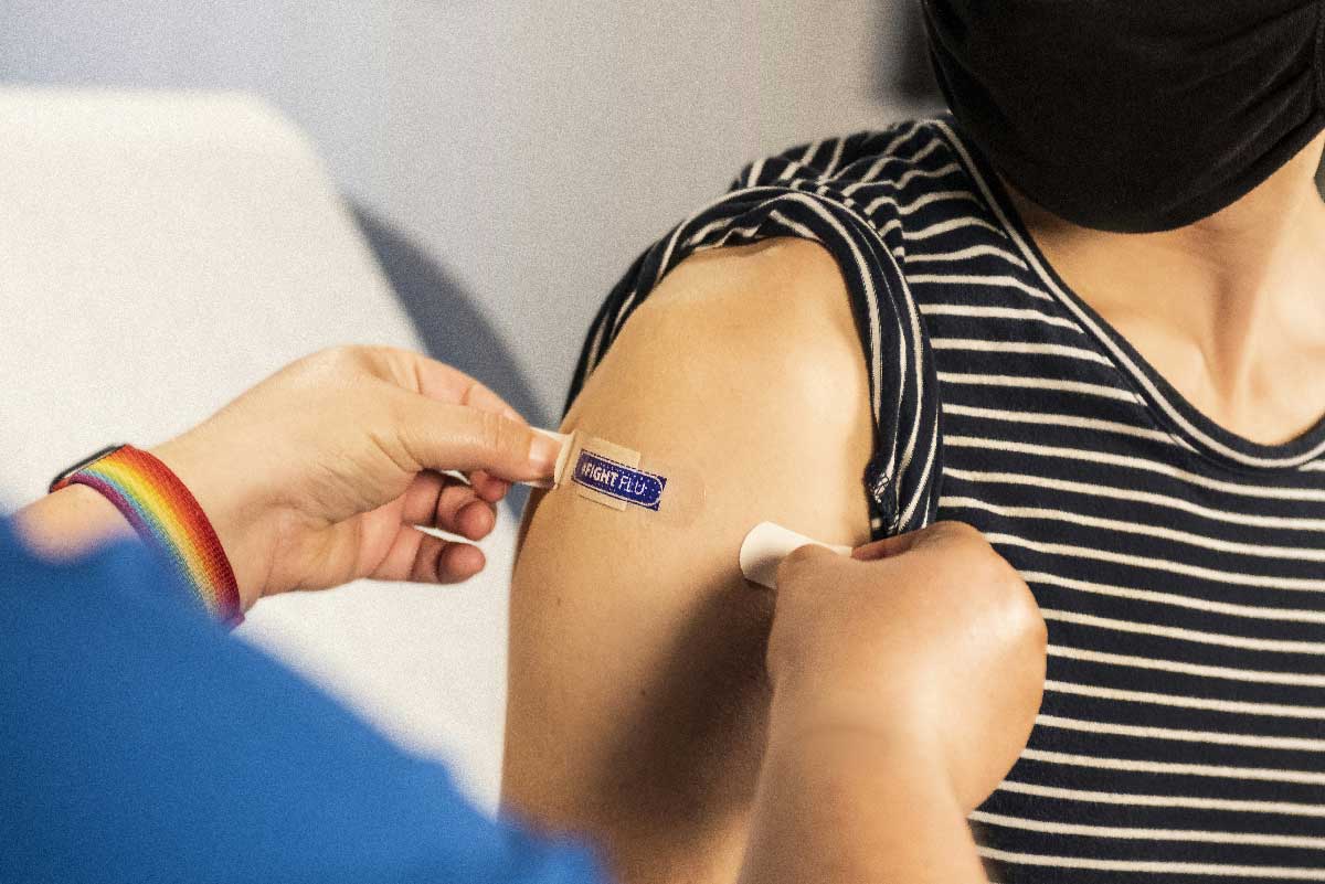 A health care provider places a bandage on the injection site of a patient, who just received an influenza vaccine. Credit: CDC/Unsplash