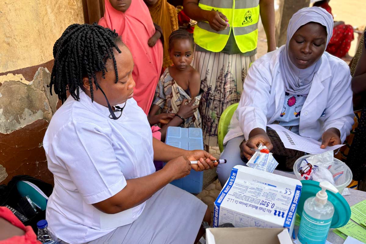 Community Health Worker, Esther O. Daniel, prepares a vaccine at Kuchigoro. Credit: Adnan Ahmad