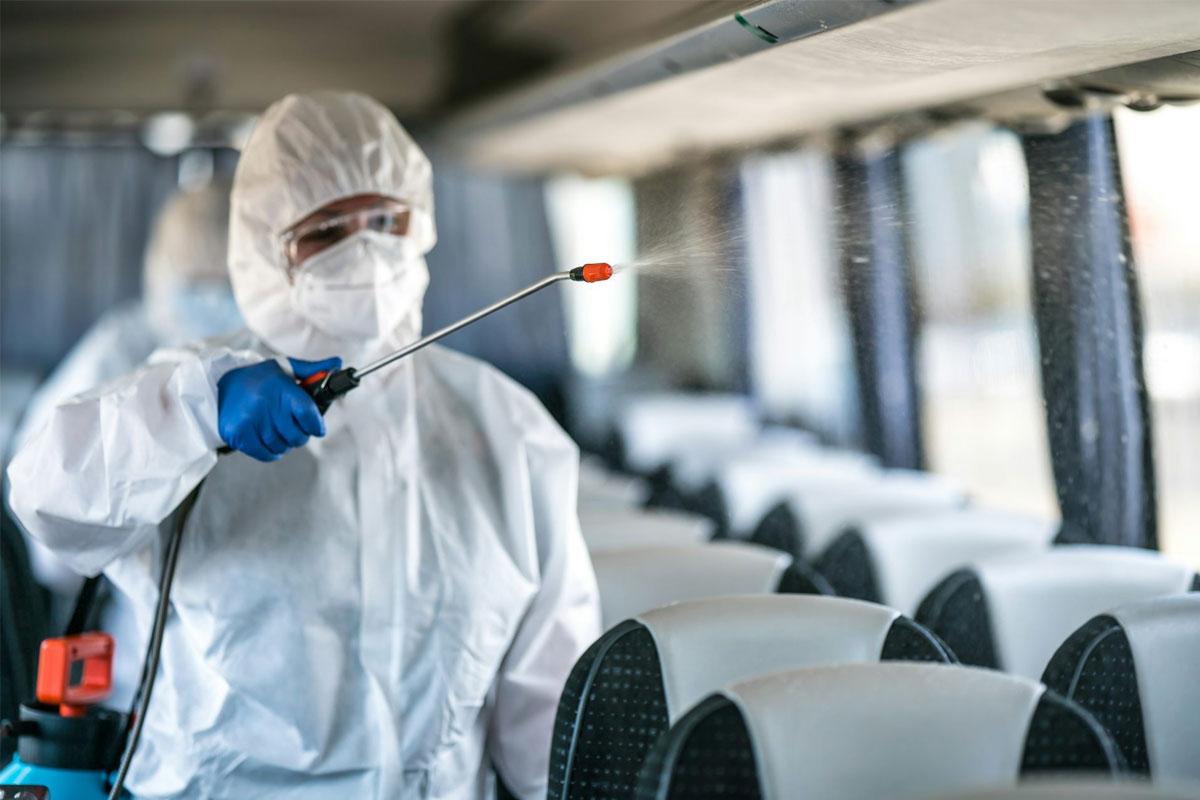 A worker spraying disinfectant to stop the spread of coronavirus. Credit: Gelefin/Shutterstock.com
