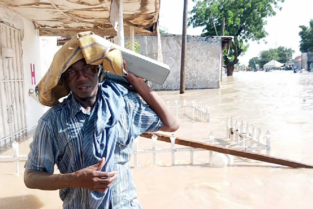 Kosollo Babashehu manuevering through the flooded streets of Maiduguri to provide immunisation services to the emergency IDP Camp at Mairi Primary School, “we are ensuring our children get protected now more than ever.” Credit: CHAN