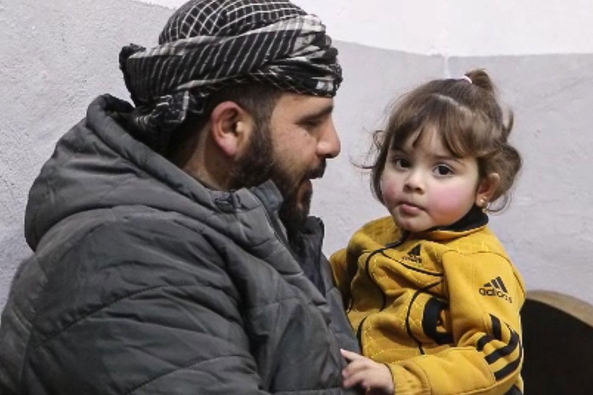 Lana sits safely in her father’s arms after recovering from meningitis in Aleppo. Credit: WHO