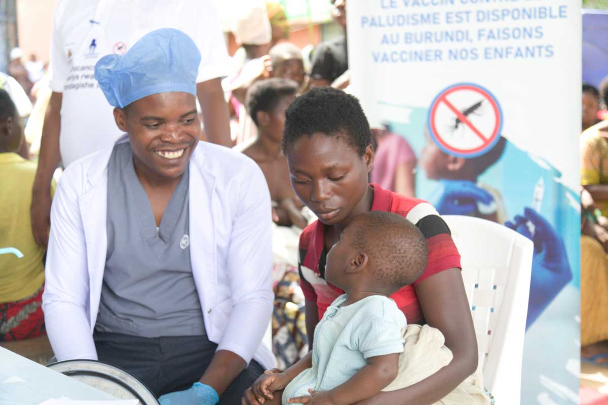 A mother with her child sits next to a health worker at the malaria vaccination session in Mpanda commune, Burundi, 20 March 2025. Credit: Moses Havyarimana